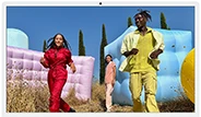 Three people in bright outfits, surrounded by colorful inflatable shapes