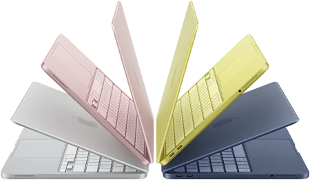 MacBook Neo laptops in silver, blush, citrus, and indigo colors, slightly open and arranged in an arch formation