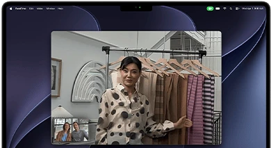 A video call on a MacBook Pro where a woman shows fabrics to two people on the call, with Center Stage keeping her centered in the frame as she moves around