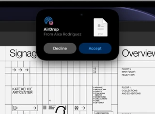 شاشة تعرض Dynamic Island مع طلب إرسال سريع يظهر في نافذة صغيرة فوق ملف Adobe Acrobat مفتوح loading=