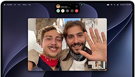 MacBook Pro with PROLED XDR Display, silver color, display shows a video call in progress with two people in a sunlit town waving to a person at home