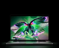 MacBook Pro with PROLED XDR Display, open lid, silver color, display shows detailed, high-contrast image with vivid colors, screen illuminates keyboard