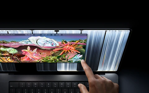 MacBook Pro with PROLED XDR Display, space black color, user resizes a window on screen with their fingertip